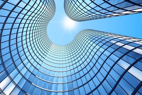 Kikkerperspectiefshot van een open bankingkantoor waar zonlicht door de binnentuin schijnt.