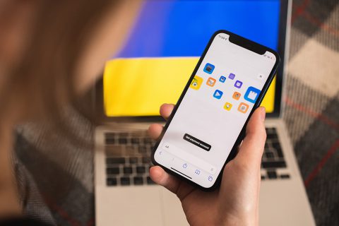 Oekraïense vluchteling gebruikt mobiele telefoon om te internetbankieren.