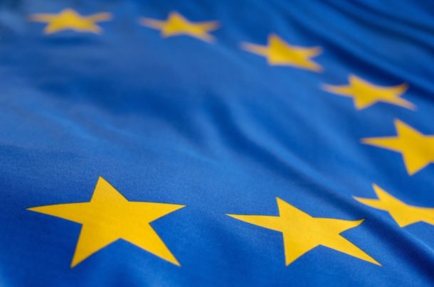 Close-up van de Europese Unie-vlag met gouden sterren op een blauwe achtergrond.